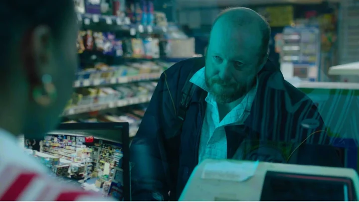 A man at a service station counter in Lucky Break